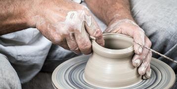 Person making clay pot